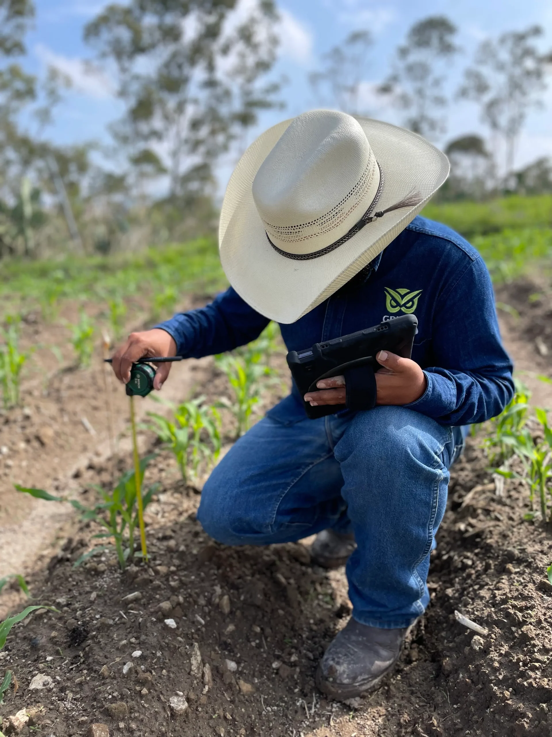 Técnico realizando medición y registro de datos en campo con apoyo de una tablet